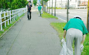 歩道のゴミを拾っている清掃活動の様子