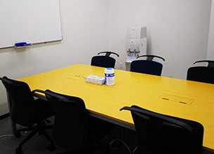 椅子と机が並び、ホワイトボードが前にある会議室
