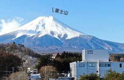 4人の男女が富士山を背に並んでいる写真